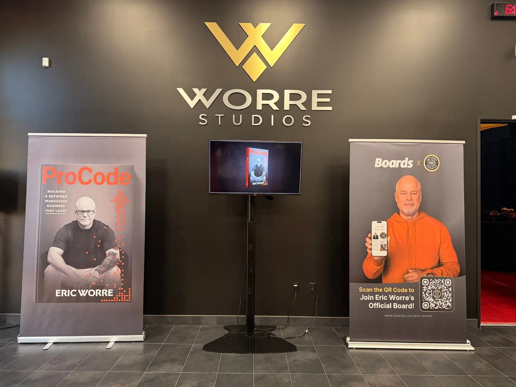 The Worre Studios illuminated logo wall flanked by ProCode and Boards pull-up banners in the lobby.