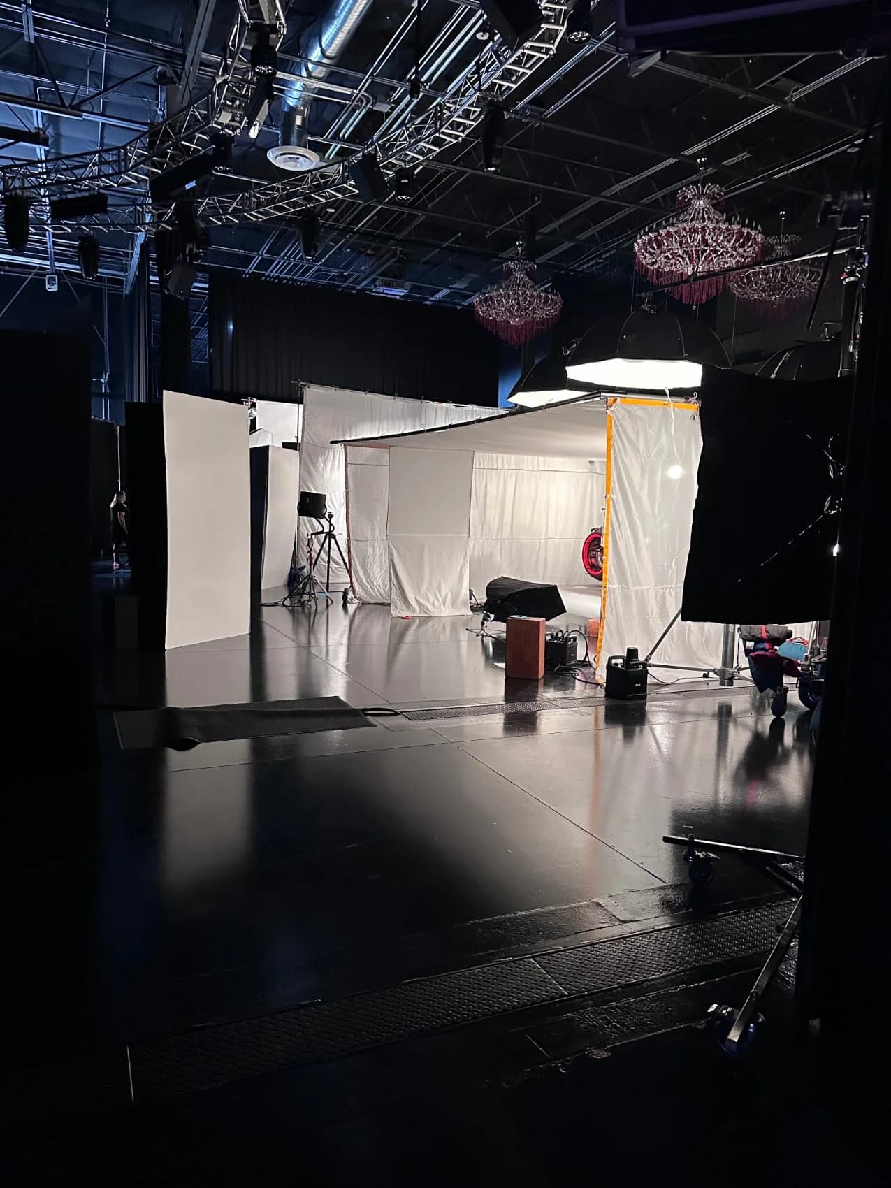 Crew and guests mingling at an outdoor lounge tent and mobile trailer set up beside the studio during a production.