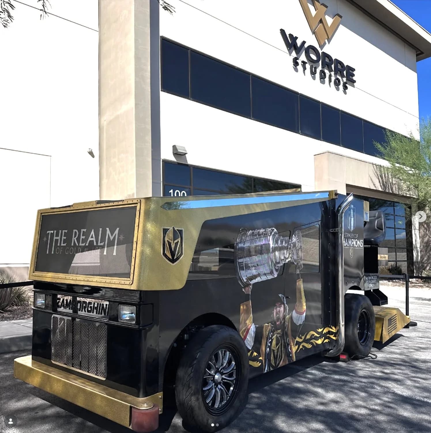 A custom gold-and-black Vegas Golden Knights Stanley Cup champions vehicle build parked outside the Worre Studios entrance.